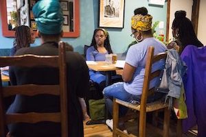 Black women sitting at a table for a workshop
